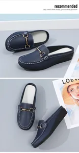 Detail von dunkelblauen Leder-Loafers mit dekorativer Schnalle und weißen Nähten.