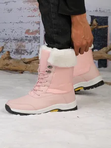Détail de bottes de neige roses avec col en fourrure blanche chaude et lacets robustes