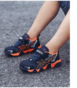 Detailed view of boys' breathable mesh running shoes with vibrant orange accents and Velcro straps.