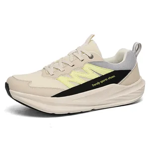 Beige hardloopsneakers met brede pasvorm, gele accenten en comfortabele dikke zool.