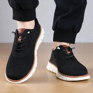 Close-up view of lightweight black mesh loafers for men featuring white soles on a wooden floor