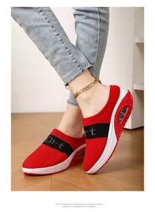 Detailed side view of women's red and black fly-woven wedge mules with air cushion soles