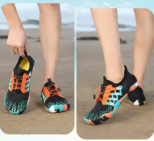 Dettaglio scarpe da scoglio colorate a piedi nudi sulla spiaggia con rete traspirante