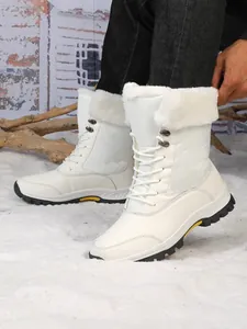 Détail de bottes de neige d'hiver blanches doublées de fourrure sur une surface enneigée