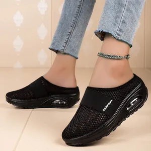 Close-up of women's black mesh walking mules featuring air-cushioned rocker soles.