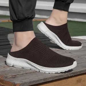 Close-up of brown fly-knit slip-on sneakers for men with thick white soles on wood