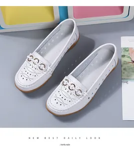Macro-opname van witte opengewerkte leren loafers met metalen ringversieringen