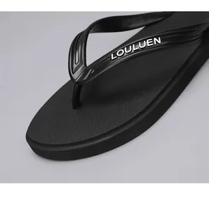Detailansicht des schwarzen Riemens und des strukturierten Fußbetts dieser schwarzen Flip-Flops