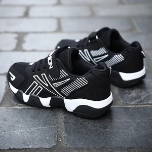 Close-up of black and white breathable mesh sneakers for kids with Velcro strap