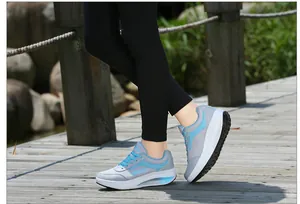 Detailed view of women's breathable mesh rocker shoes with thick soles on a wooden path