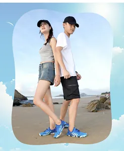 Coppie che indossano scarpe da acqua blu traspiranti su una spiaggia assolata all'aperto.