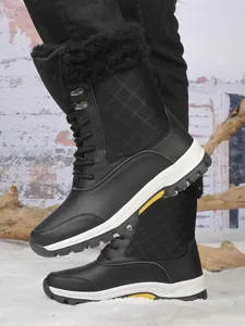 Détails des bottes de neige noires à tige haute avec doublure en fourrure et dessus matelassé.