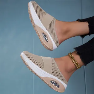 Close-up of breathable beige mesh mules with thick air-cushioned soles and elastic strap.