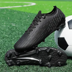 Professional black low-top soccer cleats for men training on artificial turf grass.