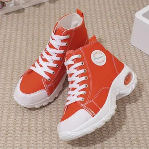Sneakers alte da donna in tela arancione con spessa suola bianca ammortizzata ad aria.
