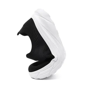 Detail view of flexible breathable black knit men's slip-on sneaker with white sole.