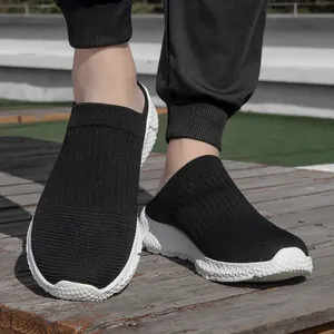 Close-up detail of men's breathable black fly-knit slip-on sneakers with soft white sole
