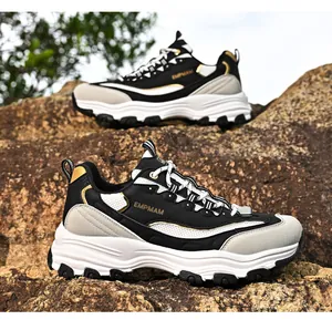 Detail outdoor view of chunky retro sneakers with thick soles and gold accents on rock