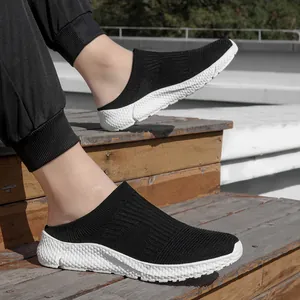 Detail view of men's breathable black knit slip-on sneakers with a textured white sole