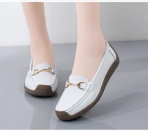 Witte leren loafers voor dames met gouden gesp en een antislip rubberen zool.