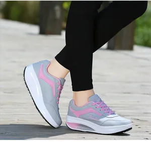 Close-up detail of gray and pink women's rocker bottom sneakers on outdoor wooden deck