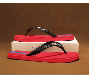 Minimalistische rote Flip-Flops mit schwarzen Riemen für den Strand im Sommer