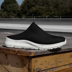 Side view detail of black knitted slip-on sneakers with white chunky textured sole