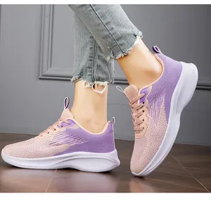 Detail shot of purple breathable knit sneakers worn on feet on a wooden floor