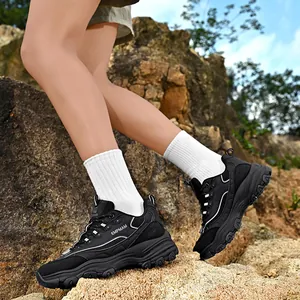 Classic black thick-sole chunky sneakers for men and women on outdoor rocks