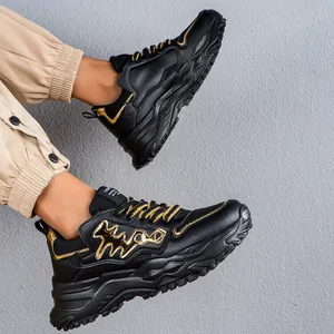 Vista dettagliata delle sneakers chunky da uomo nere e oro con suole spesse a spina di pesce