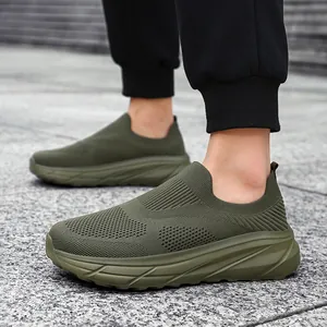 On-foot detail view of men's breathable olive green flyknit slip-on sneakers outdoors