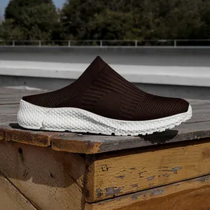 Detail view of brown fly-knit slip-on shoes with comfortable white soft sole