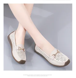 Primer plano de mocasines de cuero beige con recortes florales y detalle de metal chic