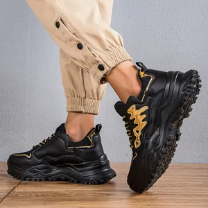 Primo piano di scarpe da ginnastica chunky nere da uomo con motivi a spina di pesce oro.