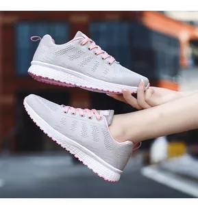 Detailed side view of breathable grey knit sneakers with pink laces and pink sole
