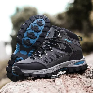 Professional men's mid-top hiking boots with non-slip rubber sole on a natural rock surface
