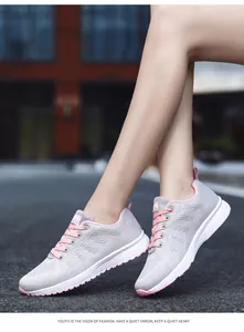 Close-up of lightweight breathable flyknit sneakers for women in gray and pink colors.