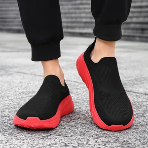 Detail of breathable black flying knit slip-on sneakers for men featuring thick red soles