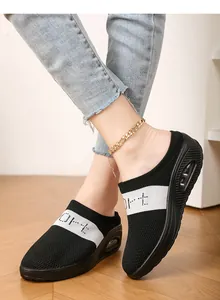 Detail view of women's black fly-knit platform mules with breathable mesh and white stripe