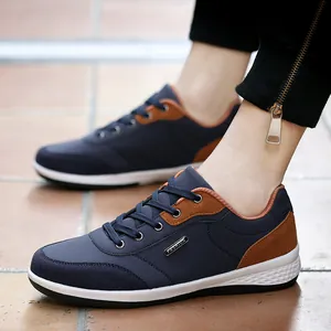Elegantes zapatillas azul marino para hombre con detalles de ante marrón y suela blanca.