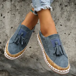 Gros plan de mocassins bleus élégants avec glands, détails en liège et semelle blanche