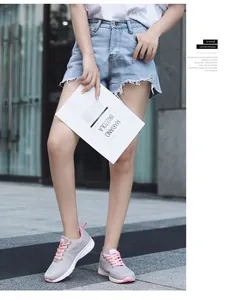 Lifestyle view of breathable grey mesh running shoes with pink laces on a female model.
