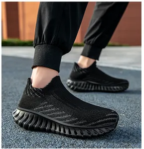 Detail showing the breathable flyknit mesh and flexible grooved sole of the black sports shoe.