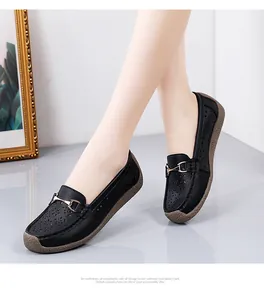 Vista detallada de mocasines de cuero negro para mujer con calados florales y hebilla dorada