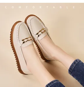 Dettaglio di mocassini in pelle beige con catena dorata e suola in gomma comoda