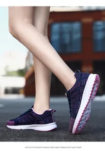 Close-up of purple breathable fly-knit sneakers worn by a model in a city street.