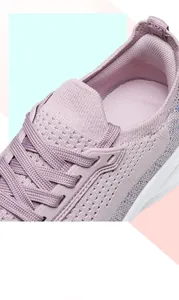 Macro view of breathable pink flyknit mesh material and laces on women's running shoe