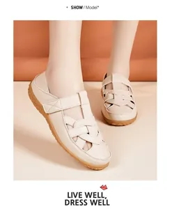 Detailed view of beige soft-sole hollow-out flat sandals worn by a model in studio