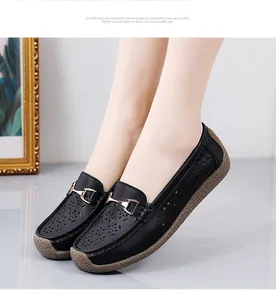 Detail van zwarte leren loafers met gouden bitgesp en bloemige perforaties