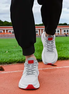 Close-up of grey breathable mesh running shoes for men on an athletic track field